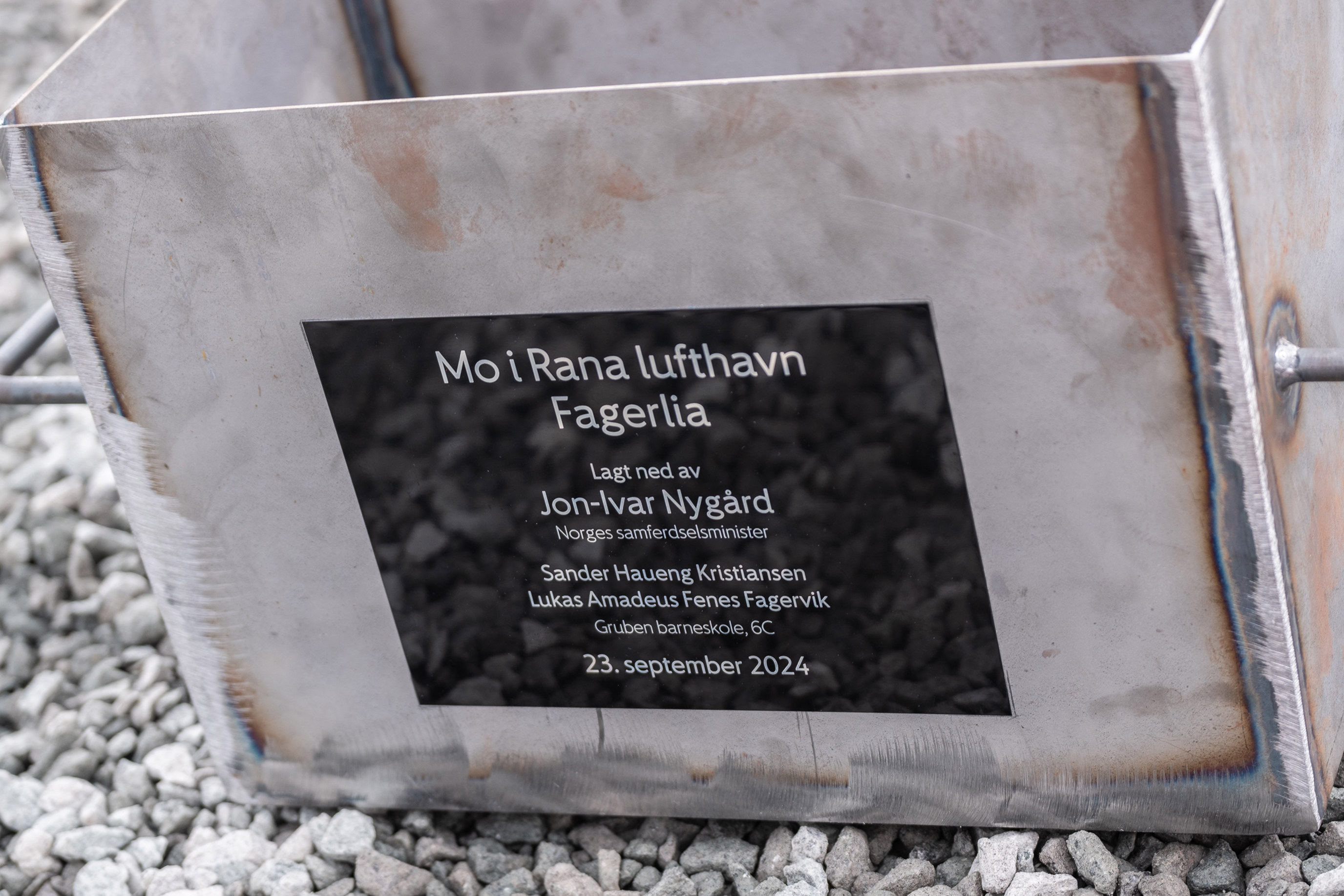 Metallboks med inskripsjon som markerer grunnsteinnedleggelse for Mo i Rana lufthavn Fagerlia, med navn og dato 23. september 2024