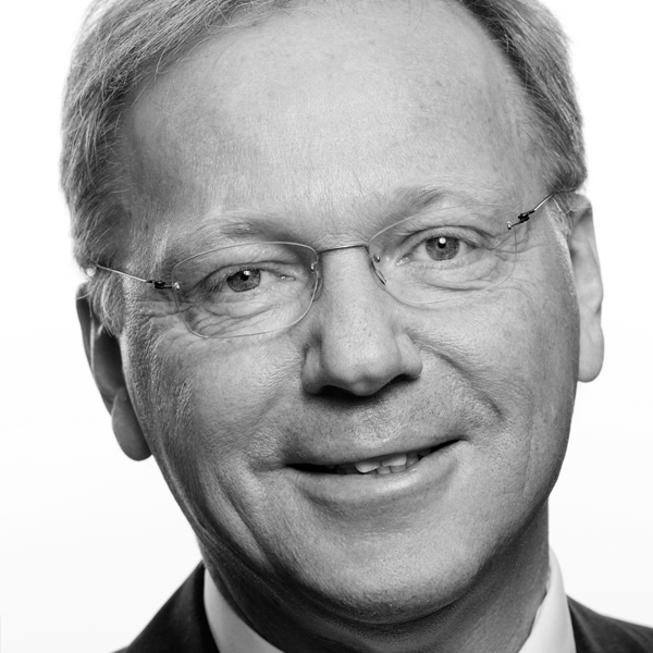 Svart-kvitt portrett av smilande mann med briller