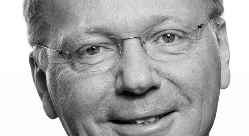 Svart-kvitt portrett av smilande mann med briller