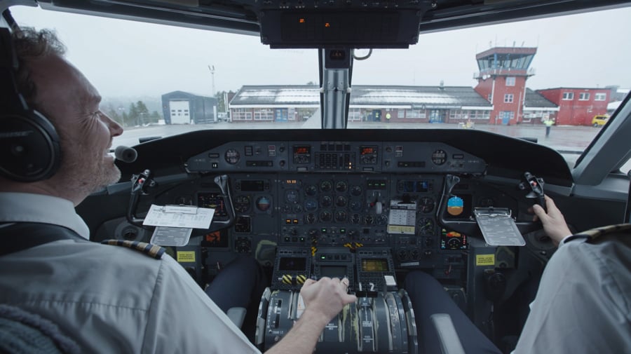 Piloter i cockpit på et trafikkfly, klare til avgang fra flyplassen.