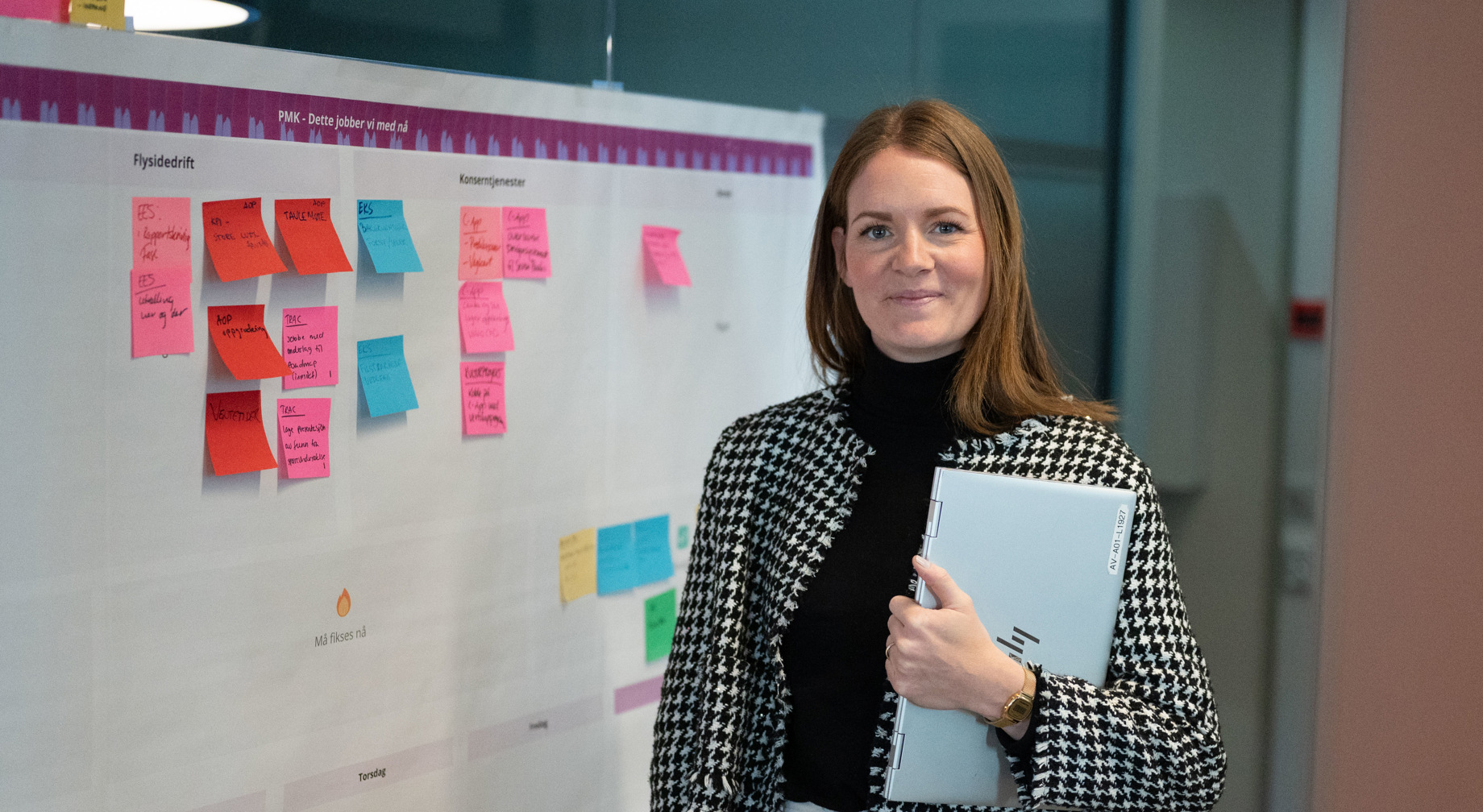 Control tower at an airport with air traffic controllers in conversation, screens in the background.
