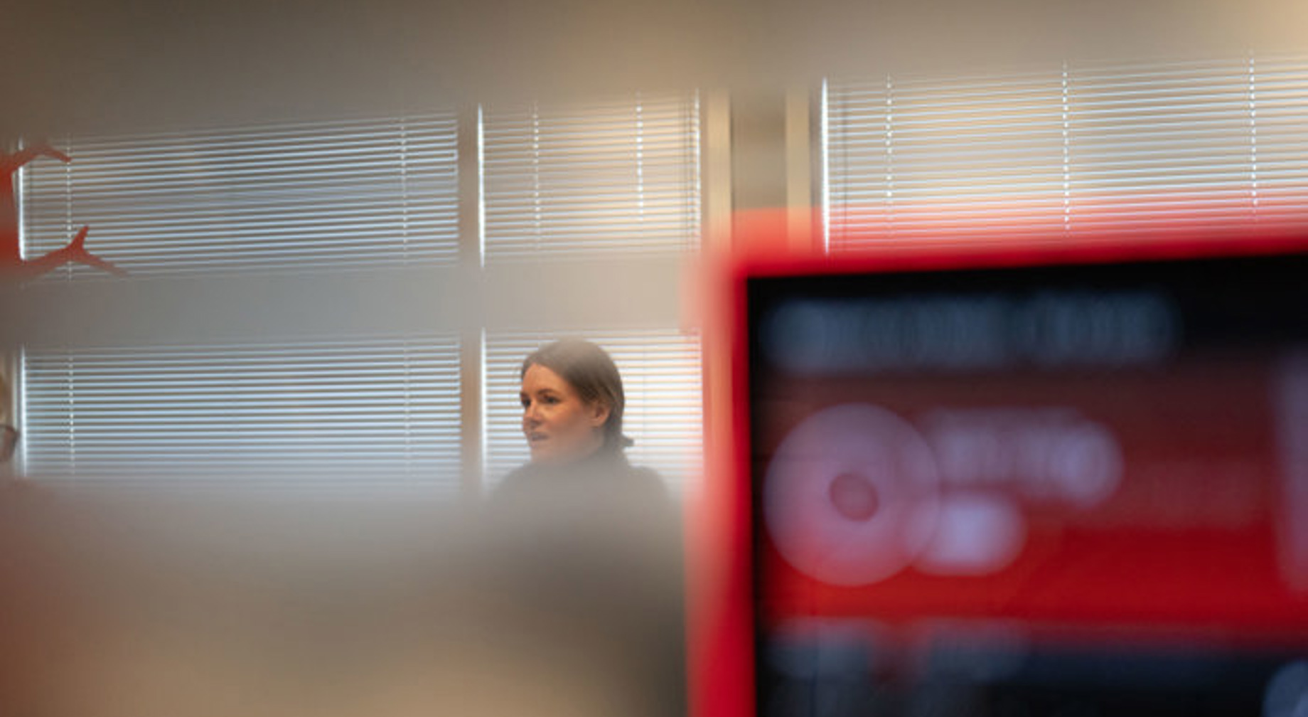 Kontrolltårn på flyplass med flygeledere i samtale, skjermer i bakgrunnen.