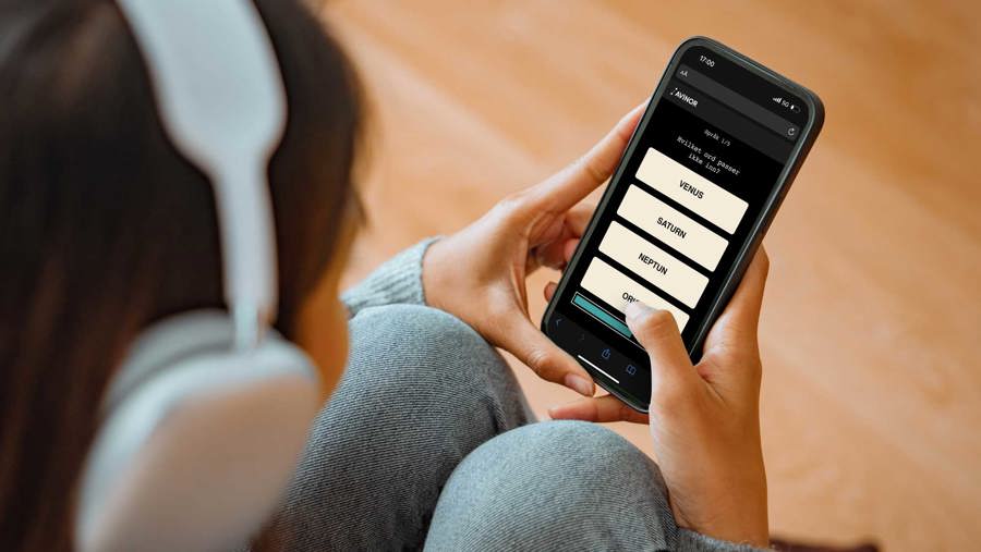 Person with headphones holding a smartphone displaying a quiz app with questions about planets.
