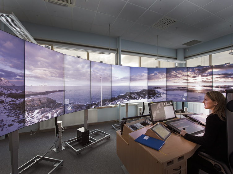 Ein AFIS-fullmektig sit på vakt ved RVT-skjermane på Bodø lufthamn.